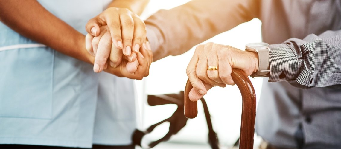 A Person Holding A Hand Of Another Person Using A Cane