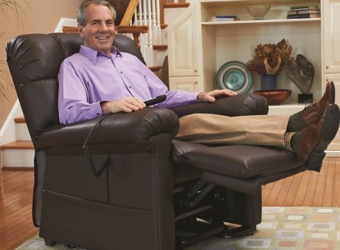 A smiling man sitting on a Golden Technoligies Comforter small to tall lift chair recliner