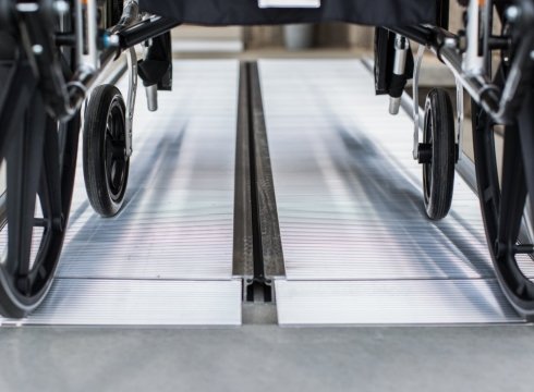 Close up of a wheelchair on a portable ramp installed on a step