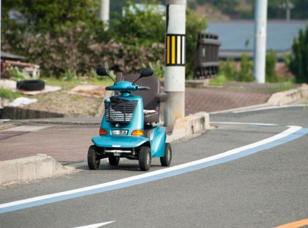 A blue scooter in the street.