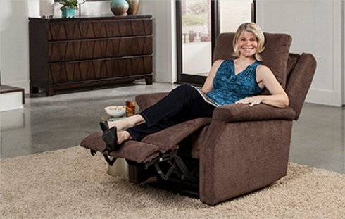 A happy woman sitting on a brown lift chair