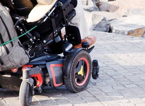 A person in a power wheelchair parked on a jetty