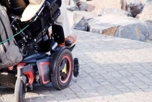 A Person In A Power Wheelchair Parked On A Jetty.