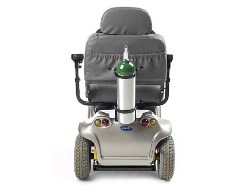 A power wheelchair shown from behind with a oxygen tank holder